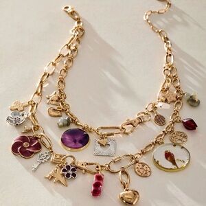 Free People Maxamillon Gold Necklace, adorned with purple and red charms.